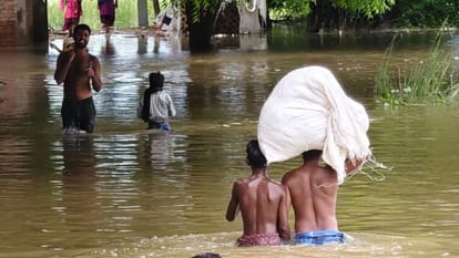 जलभराव के बीच गंतव्य को जाते ग्रामीण।