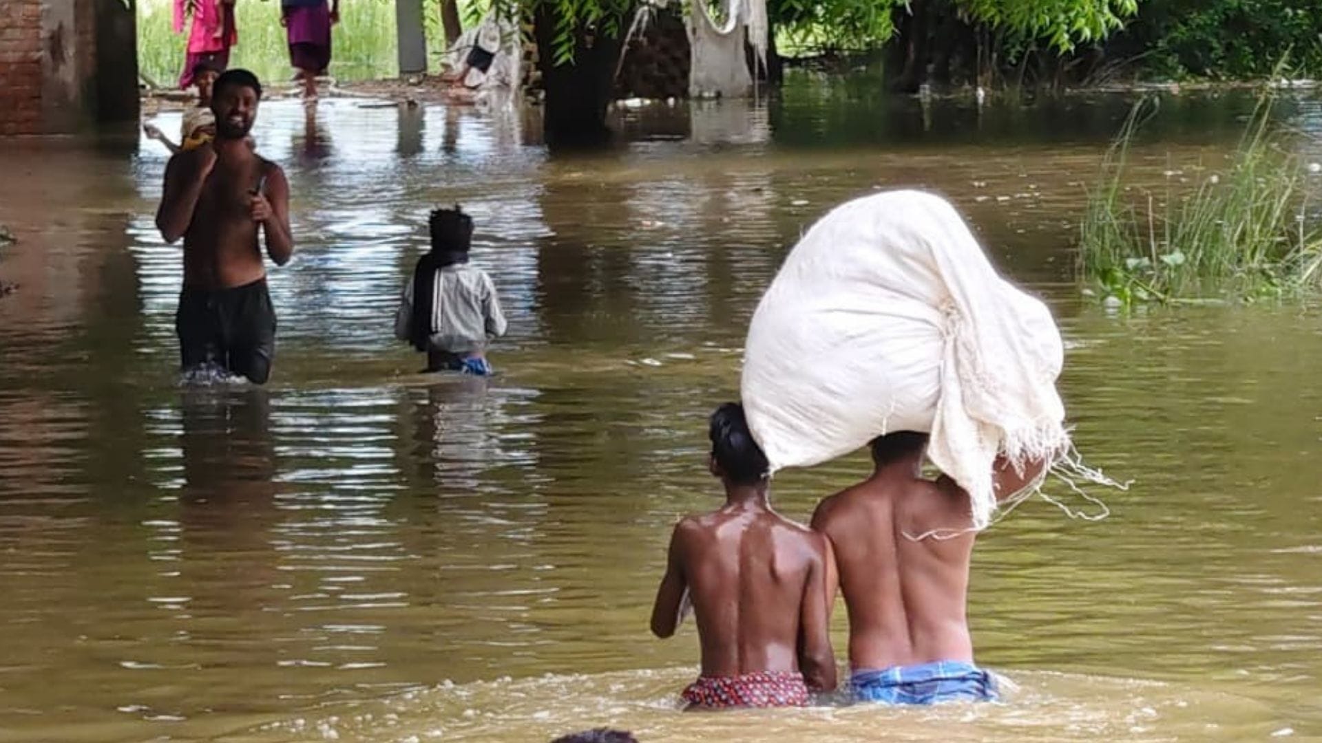 जलभराव के बीच गंतव्य को जाते ग्रामीण।