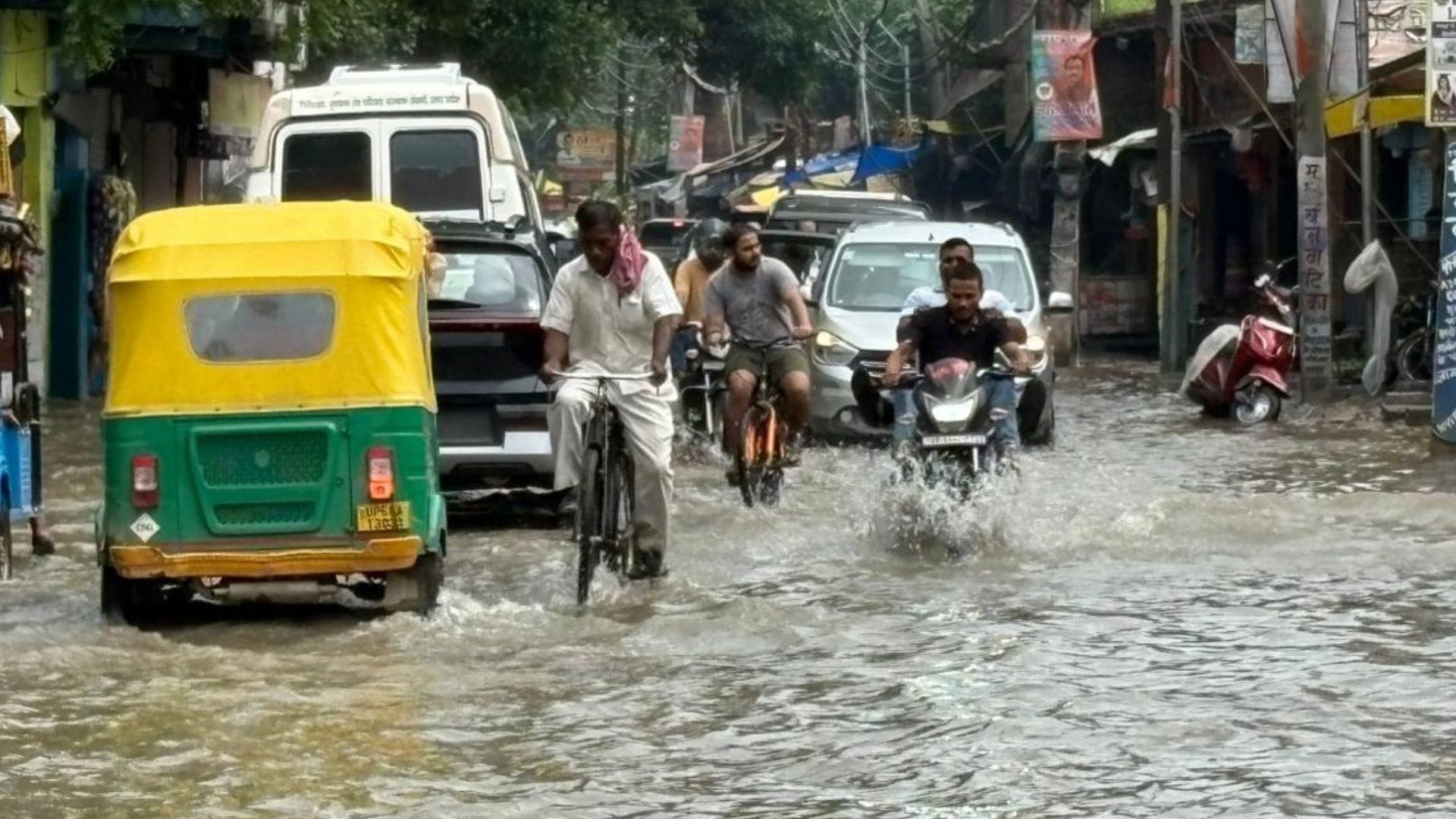 Rain from city to village in varanasi Knee-deep water people forced to drag two wheelers difficult