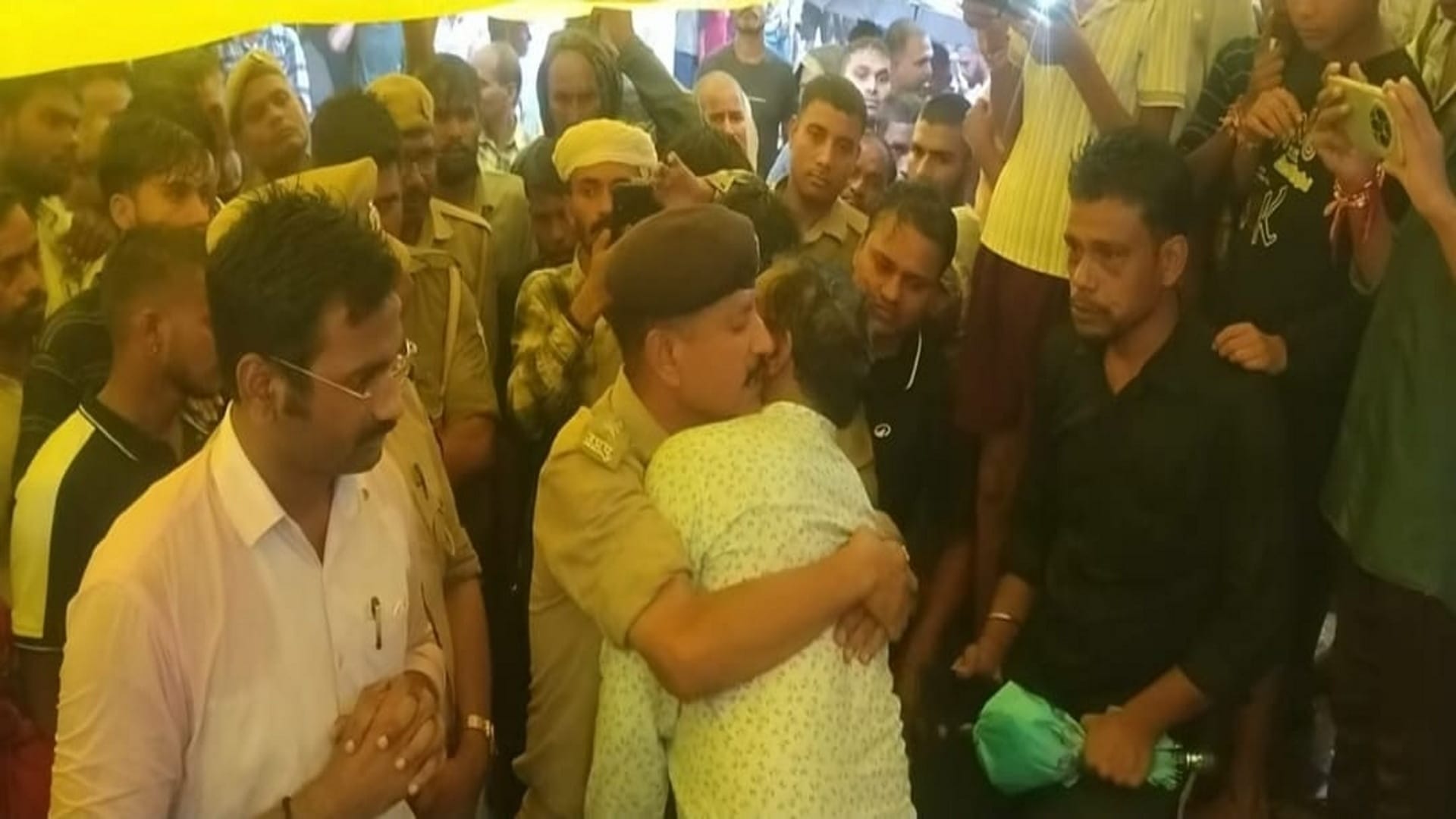 गया प्रसाद के बच्चों के शव पहुंचने पर भाई दुर्गा प्रसाद को गले लगाकर सांत्वना देते सीओ सिराथू।