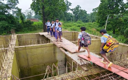 a swift river below, school bags above; children trudge to school via the stairs of an unfinished bridge