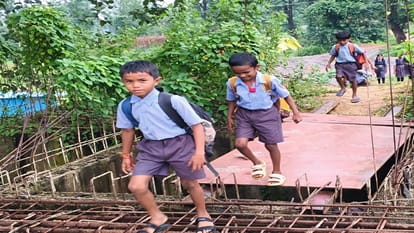 a swift river below, school bags above; children trudge to school via the stairs of an unfinished bridge