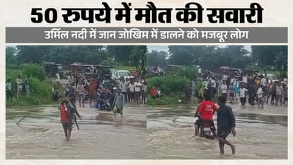उर्मिल नदी के तेज बहाव को पार करते लोग
