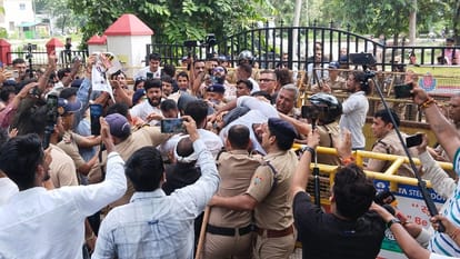 बैरिकेड पर चढ़ते कार्यकर्ता को धकेलती पुलिस।