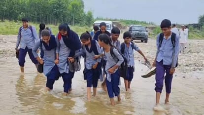 नदी पार करते स्कूली बच्चे