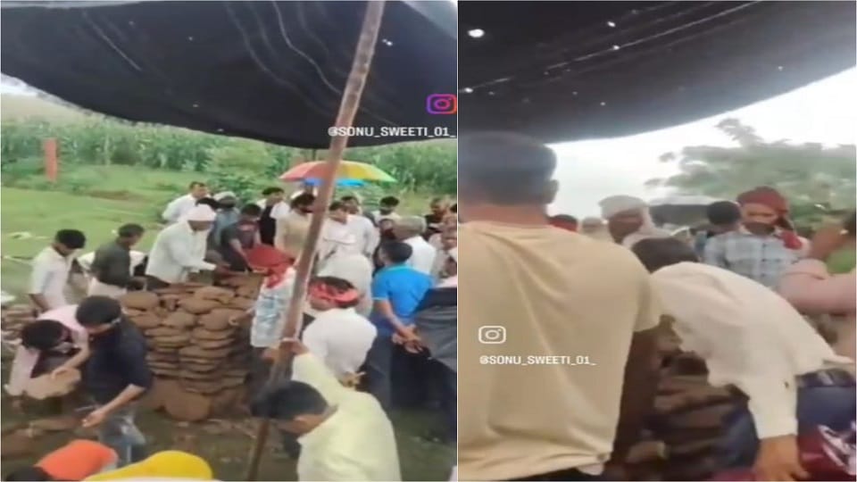 Funeral pyre lit under tarpaulin amidst rain in Agra