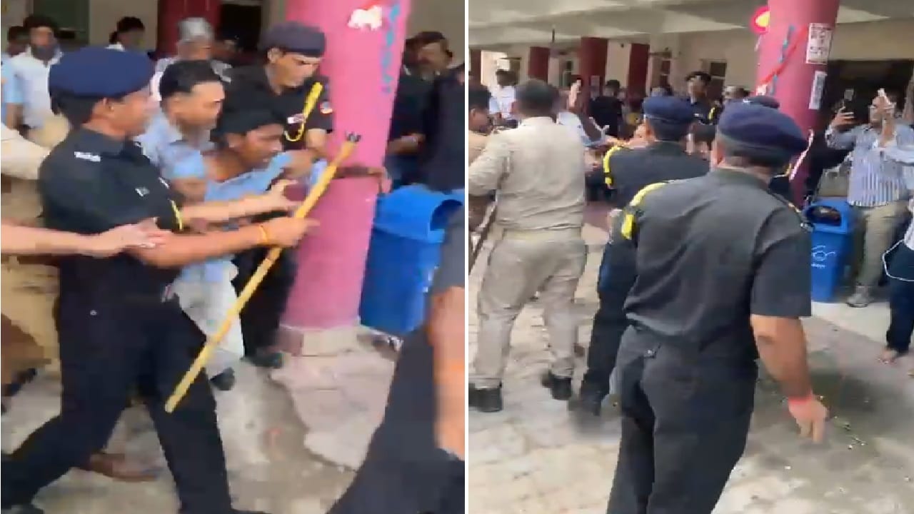 प्रदर्शनकारियों को पकड़े सुरक्षाकर्मी