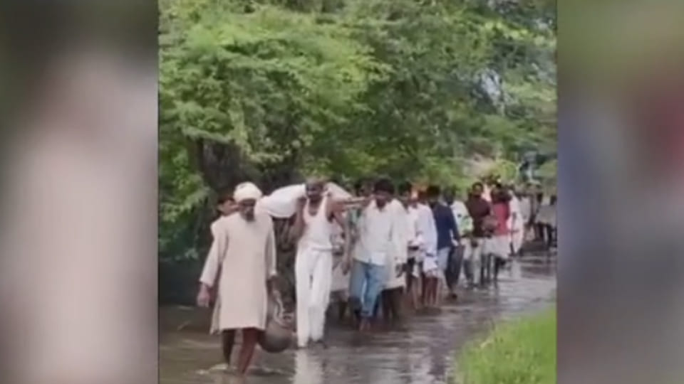 श्मशान घाट मार्ग पर भरे पानी के बीच अर्थी ले जाते परिजन व ग्रामीण