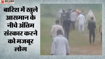 बारिश के बीच खुले में हो रहा अंतिम संस्कार