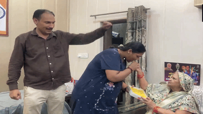 एक-दूसरे को मिठाई खिलाते दीप्ति शर्मा के परिजन।