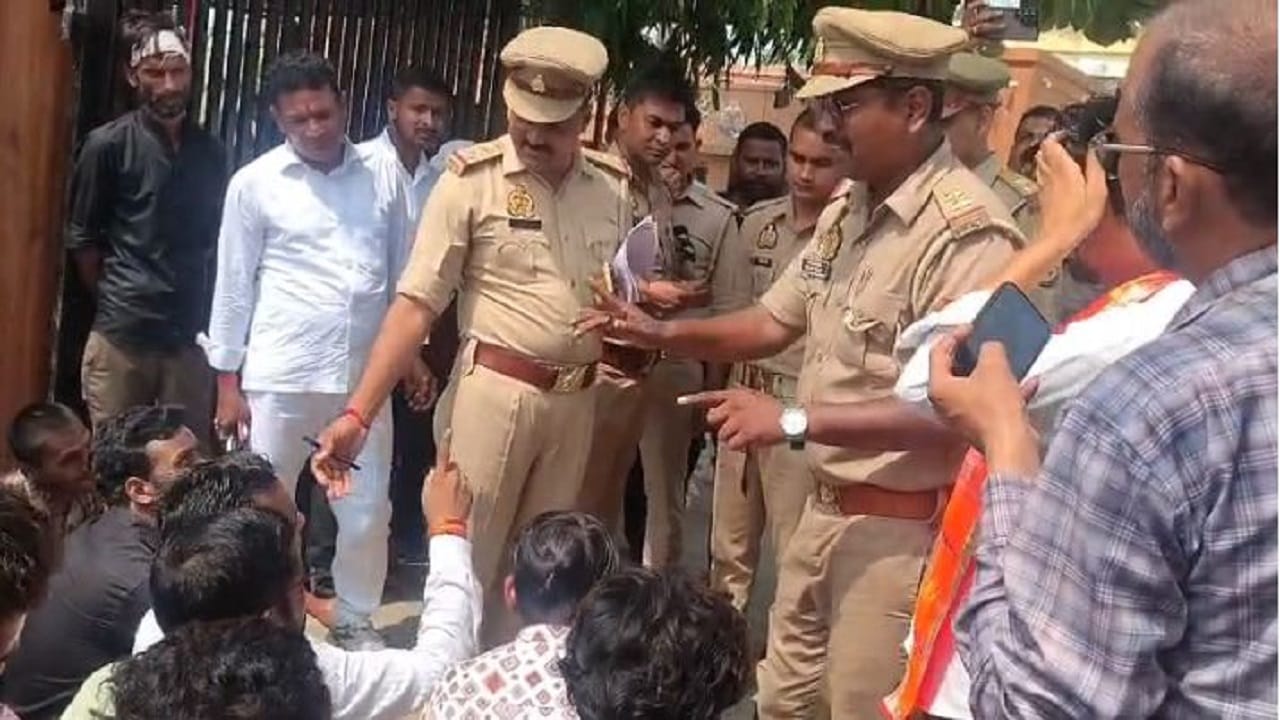 कार्यकर्ताओं से बात करते पुलिस अधिकारी