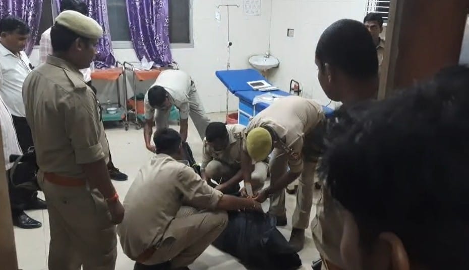 युवक की लाश को कब्जे में लेती पुलिस।