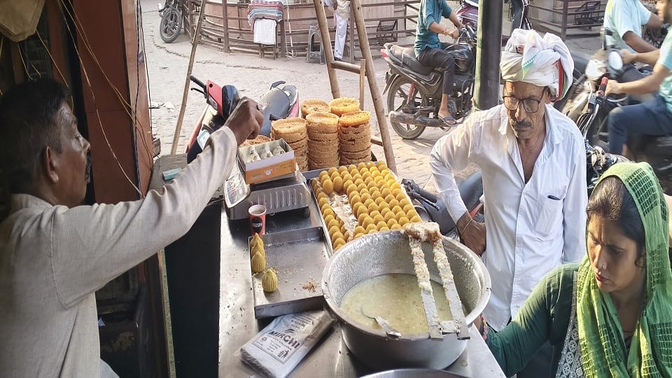 शहर के घंटाघर स्थित एक दुकान पर मोदक खरीदते ग्राहक