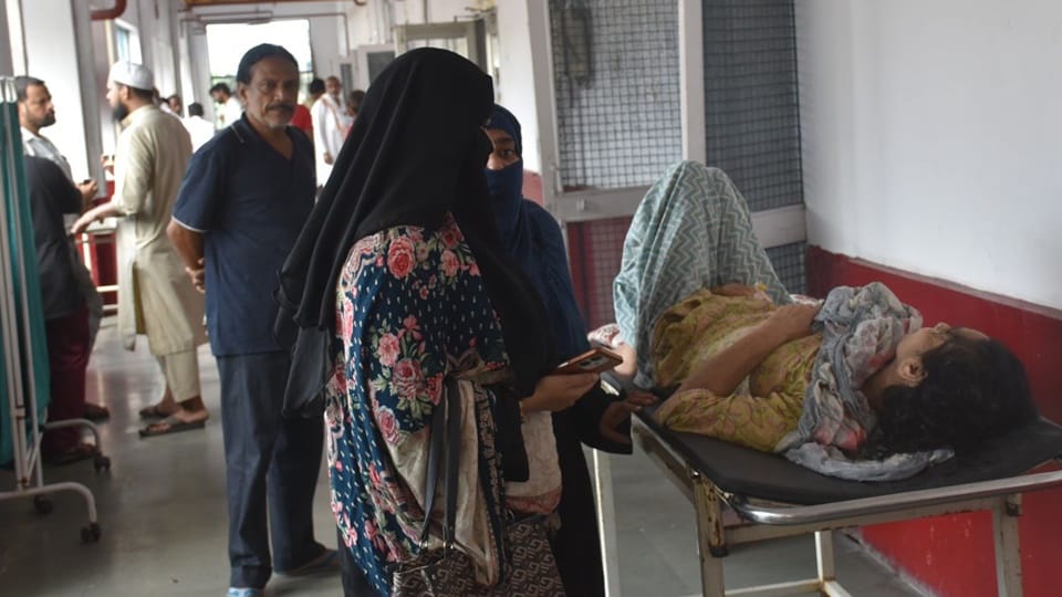Two patients sharing a single bed at Moradabad District Hospital; this situation has persisted for five days