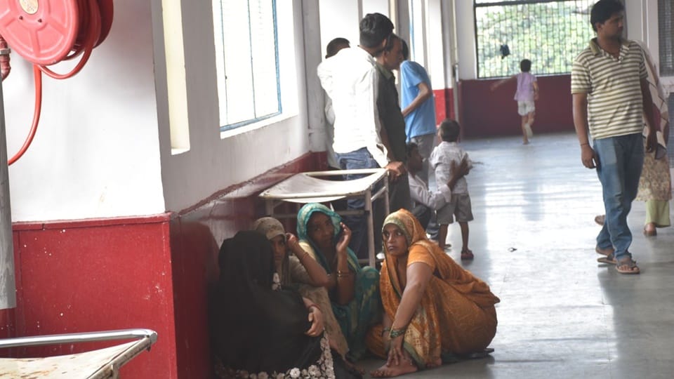 Two patients sharing a single bed at Moradabad District Hospital; this situation has persisted for five days
