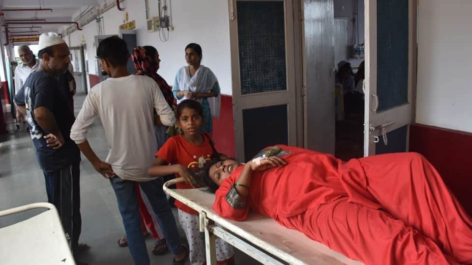Two patients sharing a single bed at Moradabad District Hospital; this situation has persisted for five days
