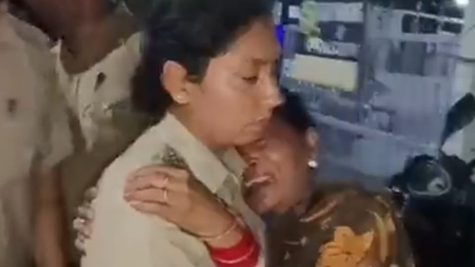पुलिसकर्मी के गले लगकर बिलखती महिला