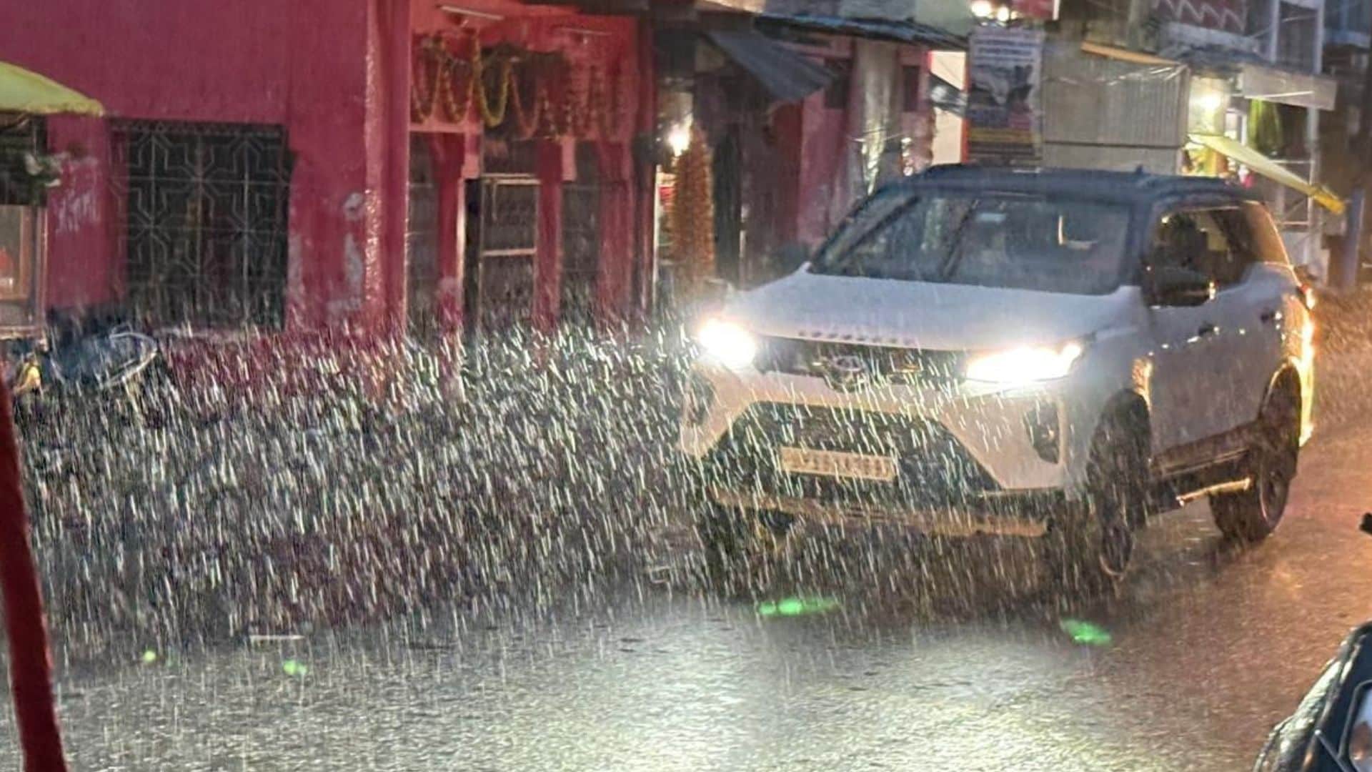 भारी वाहन के बीच जाती कार।