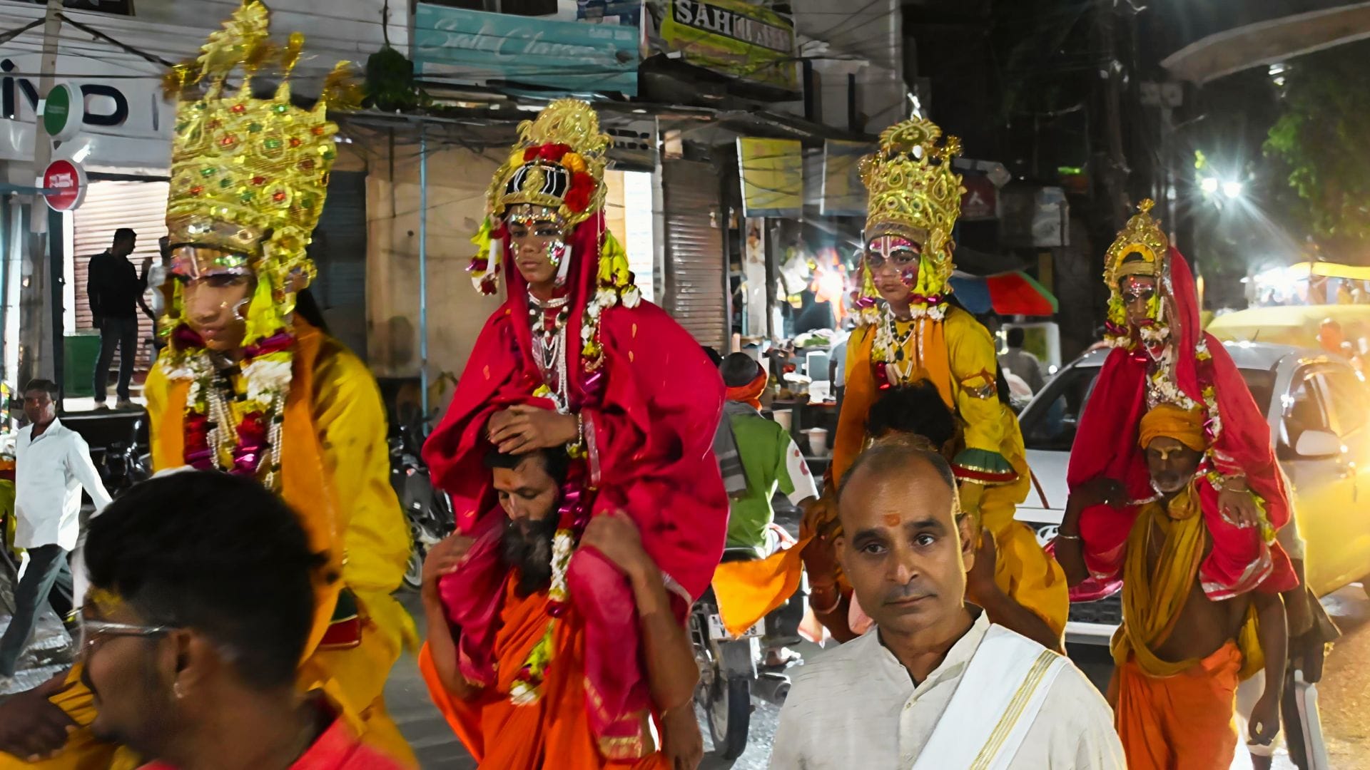 परंपरानुसार चारों भाइयों को कंधे पर लेकर जाते पुरोहित।