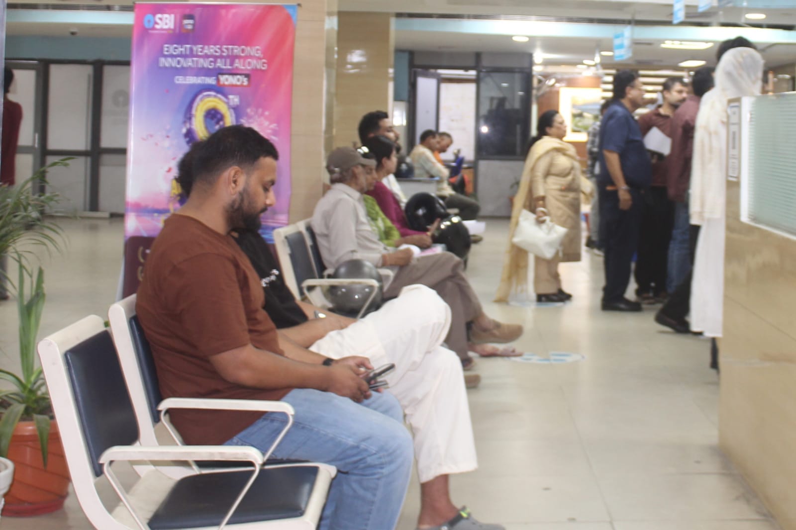 हरि मार्केट स्थित एसबीआई बैंक में लोग।