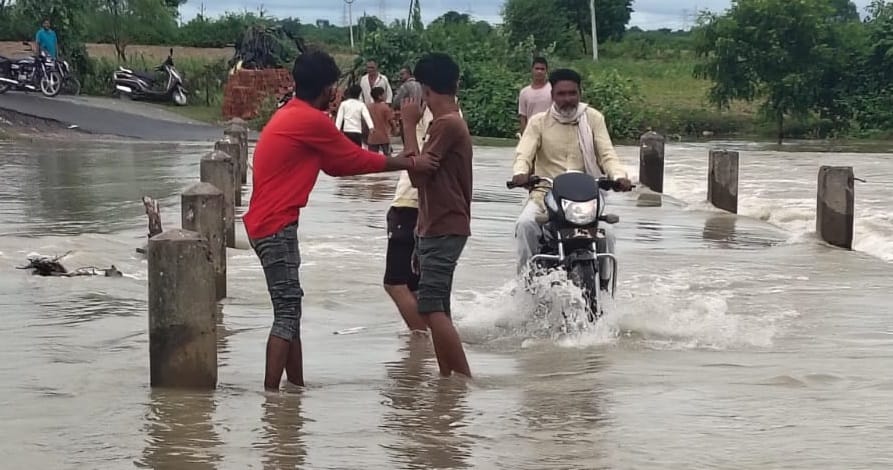 Jalaun Noon River causeway submerged water flowing one foot above surface traffic continues despite currents