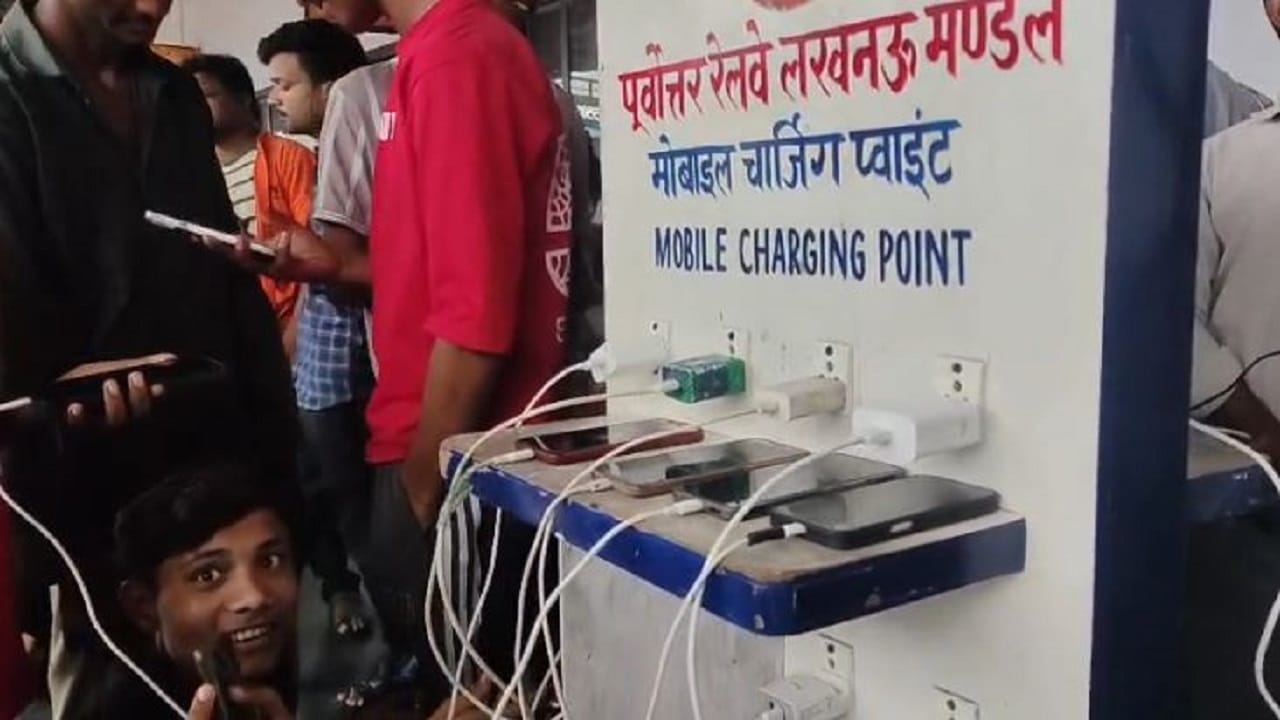 रेलवे स्टेशन पर फोन चार्ज करते युवक