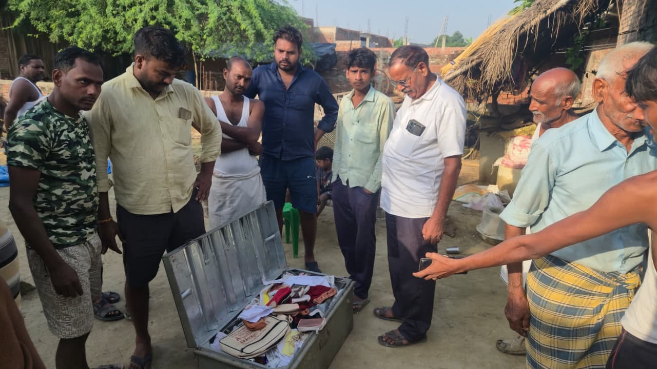 घर के बाहर पड़ा बक्शा देखते ग्रामीण