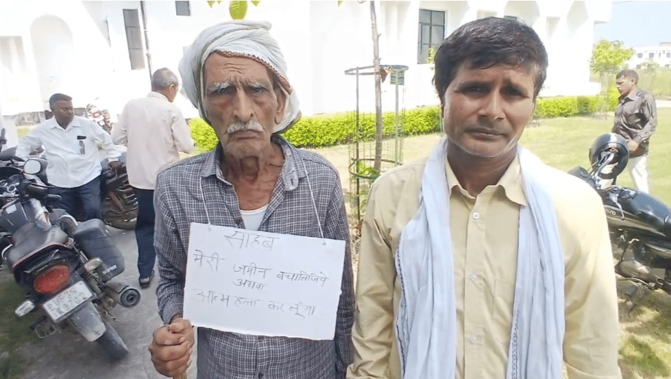 अमेठी: गले में पोस्टर लटकाकर डीएम कार्यालय पहुंचा किसान, जमीन बचाने की लगाई गुहार, आत्महत्या की चेतावनी दी