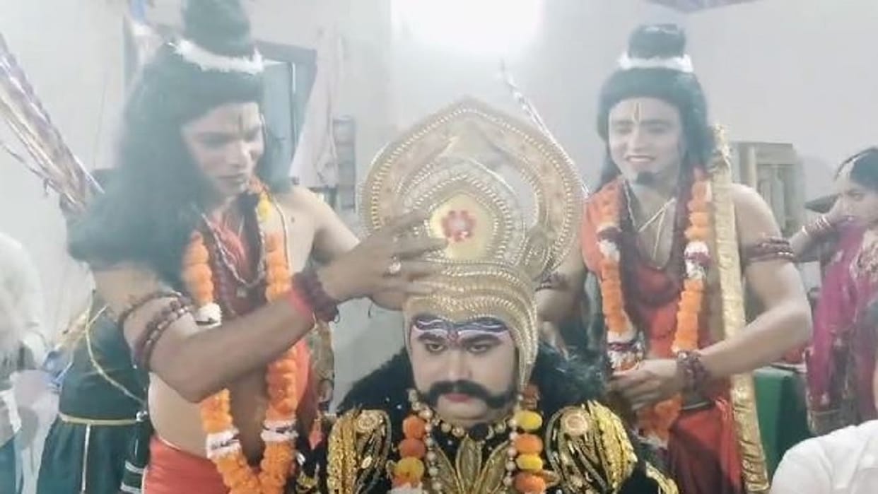 'Ram' and 'Lakshman' place a crown on 'Ravana' behind the scenes at Ramlila in Shahjahanpur
