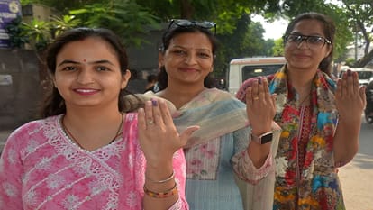 मतदान करने के बाद उंगली पर लगी स्याही दिखाती महिलाएं।