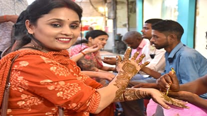 करवा चौथ पर मेहंदी लगवाती महिलाएं