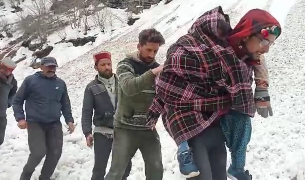 Elderly woman carried on back and taken to hospital