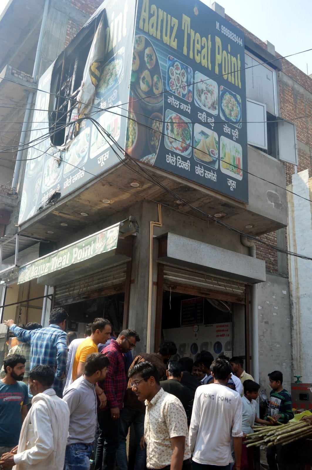 A crowd gathered during a fire at a fast food shop in Sarai Chowpata Chowk