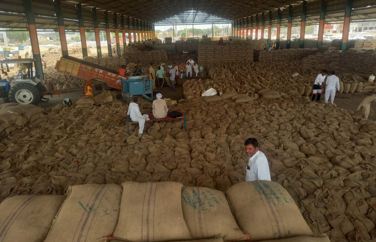 After picking up the bags of mustard and wheat in the grain market, the farmer is waiting for the payment outside.