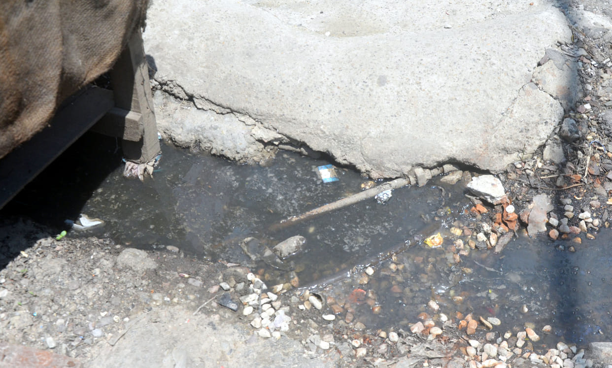 Water flowing on the road from blocked drainage drains, people upset