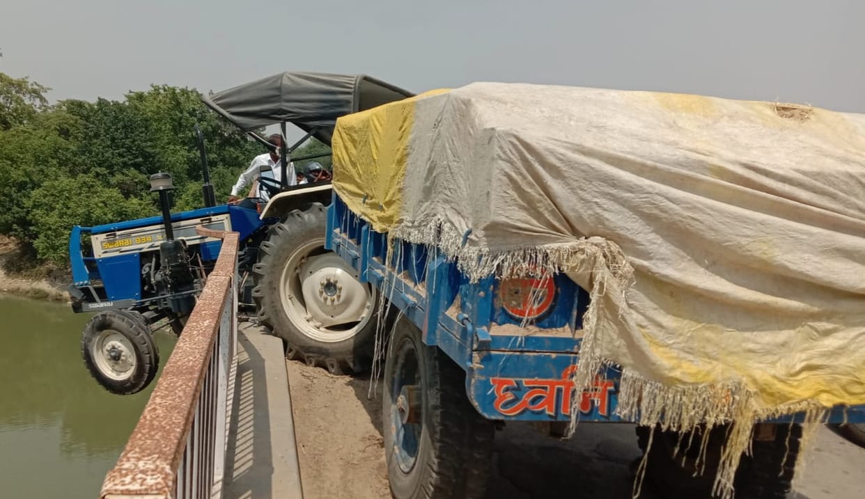 Breaking railing of the bridge, tractor hanged towards river