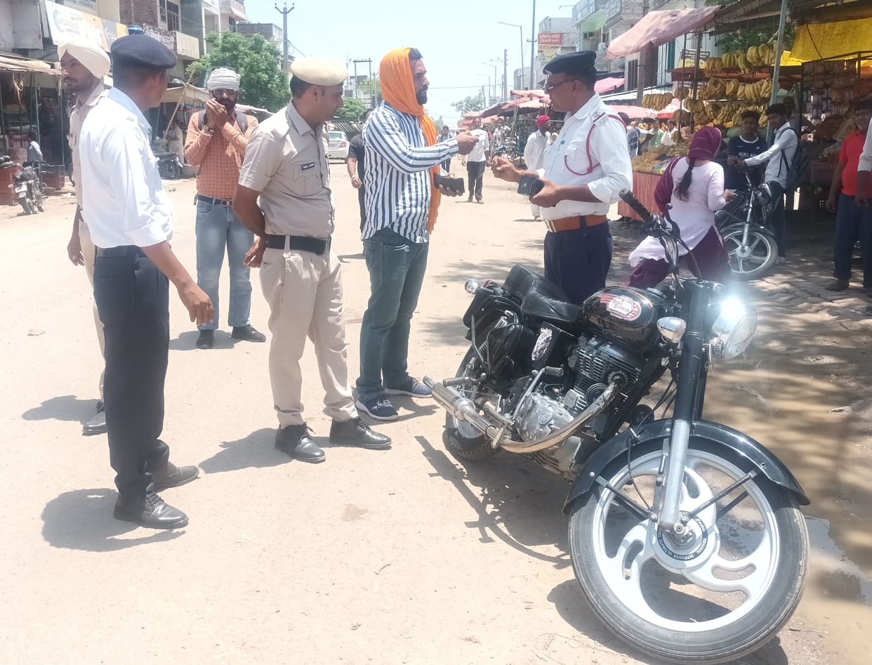 Policemen cutting the challan of bullet driver in Jakhal.