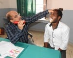 मेडिकल कालेज के ओपीडी में मरीज के गले की जांच करते प्राचार्य डॉ एके झा।