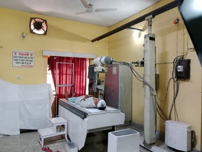 A radiologist, working, in the digital X-ray machine compartment