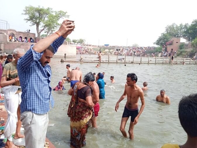 Devotees take a dip at Pindara Tirtha on the new moon day of Ashadh month