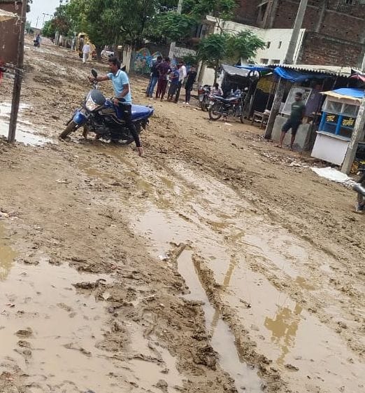 Road drenched in mud in the rain, passers by upset