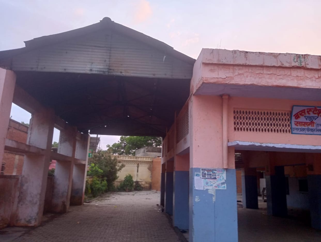 dilapidated bus stand, passengers are making difficult journey