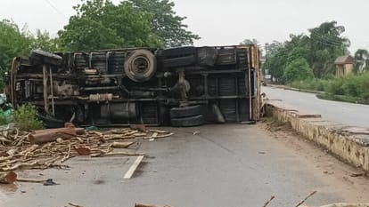 Truck full of wood overturned on the middle of the road after colliding with the deviator