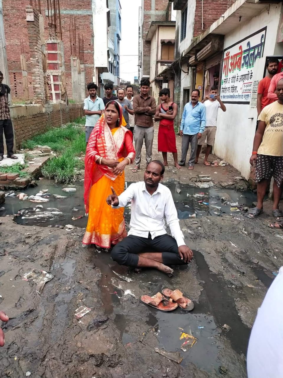 Female councilor sitting on dharna with her husband in the mud for cleanliness
