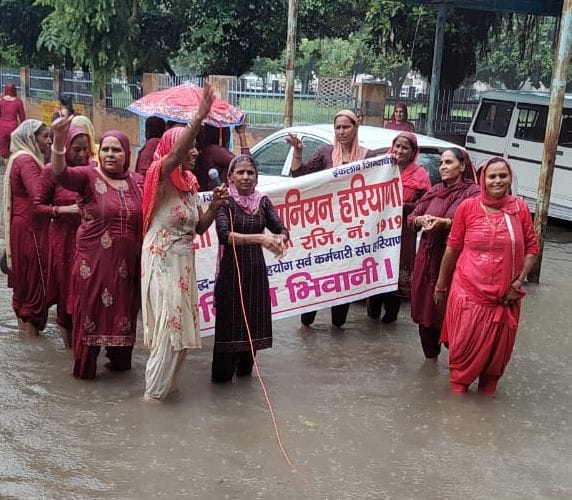 Asha workers demonstrated in waterlogged during rains
