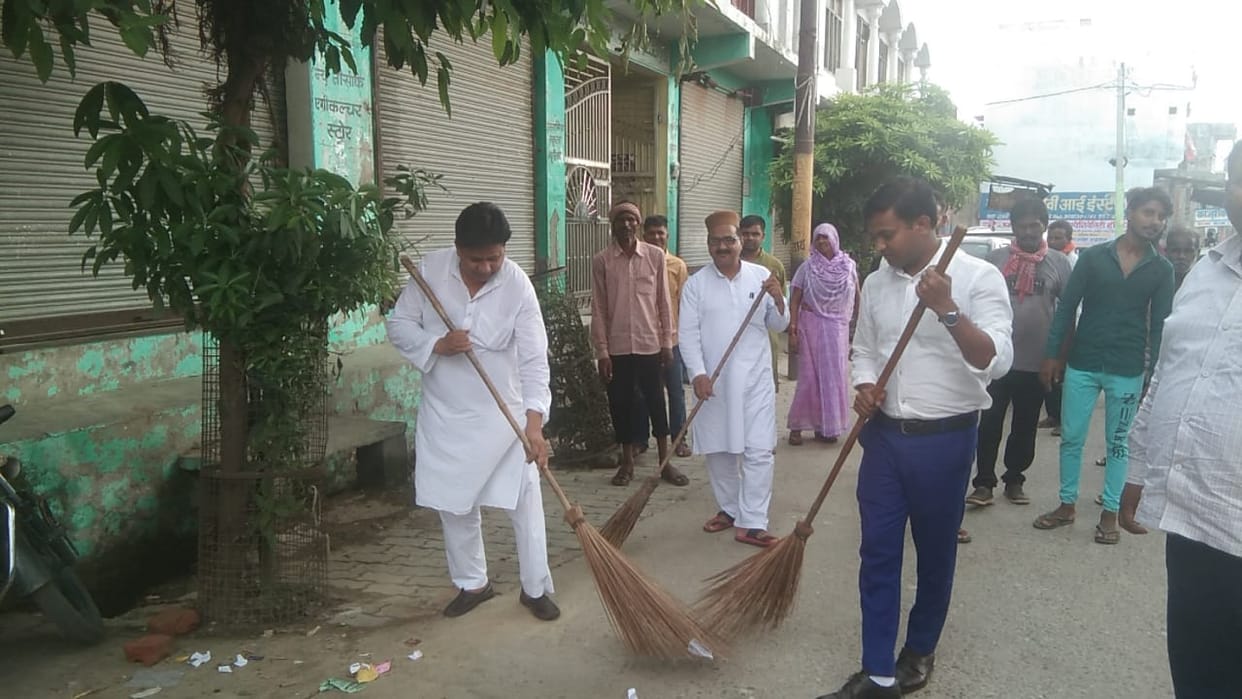 EO and chairperson's husband sweeps the road
