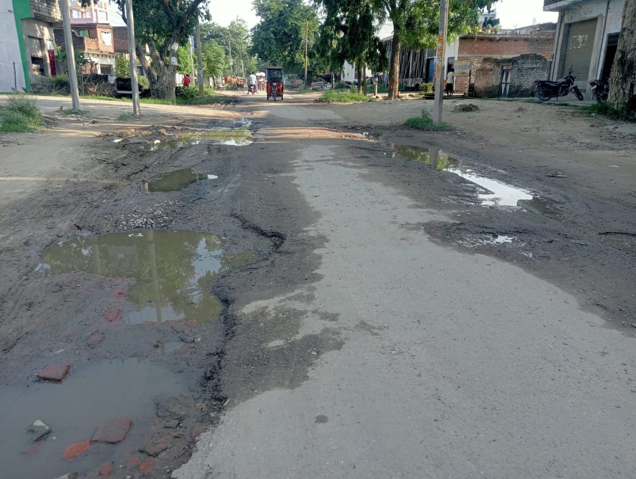 Kavandia passing through the water filled on dilapidated road