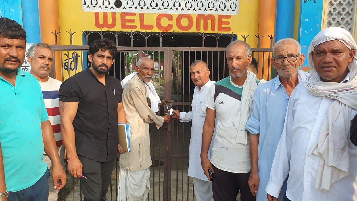 Villagers lock the school gate in Ghilaud Kalan