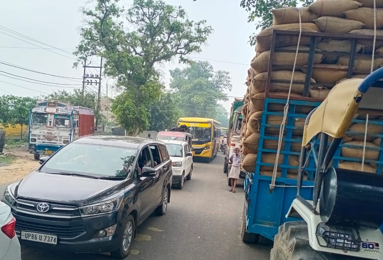School vehicles stuck in the jam of vehicles loaded with millet