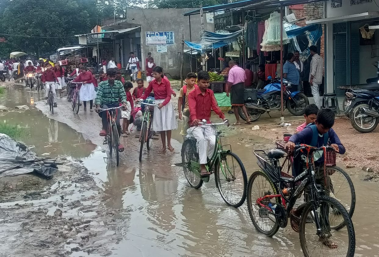 Passengers upset due to water logging in the potholes of the broken road
